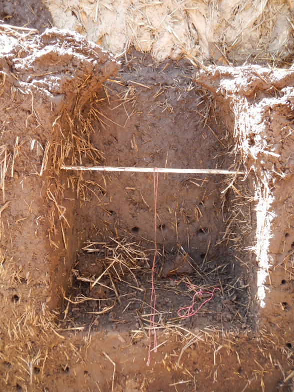 We continued to build up the tops of the columns by thickening them and shaping them like a front of a boat. The stick in the middle is a measurement guide, with a string tied to the middle to help us trace out a semi-circle for the top of the arch.
