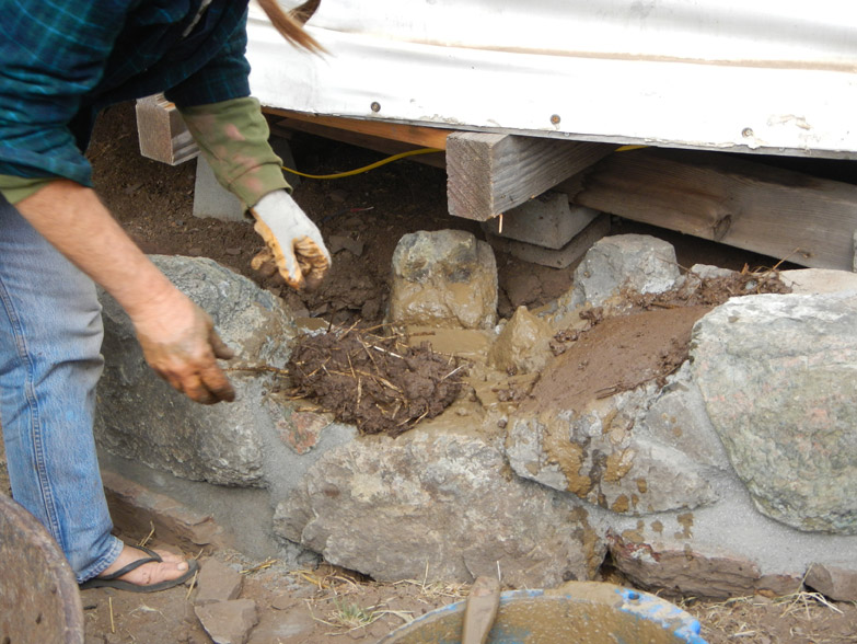 Then we apply cob directly to the stone foundation to begin the wall!