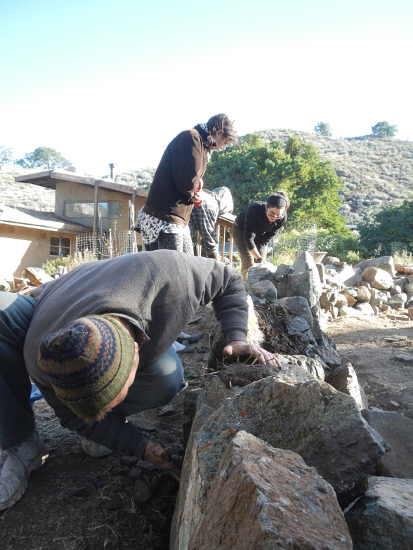 Putting first batch of cob on the foundation rock based