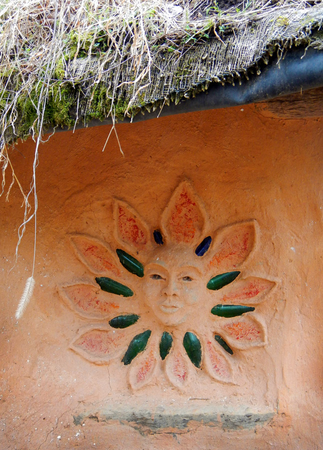 Sun design on a side of the round strawbale house